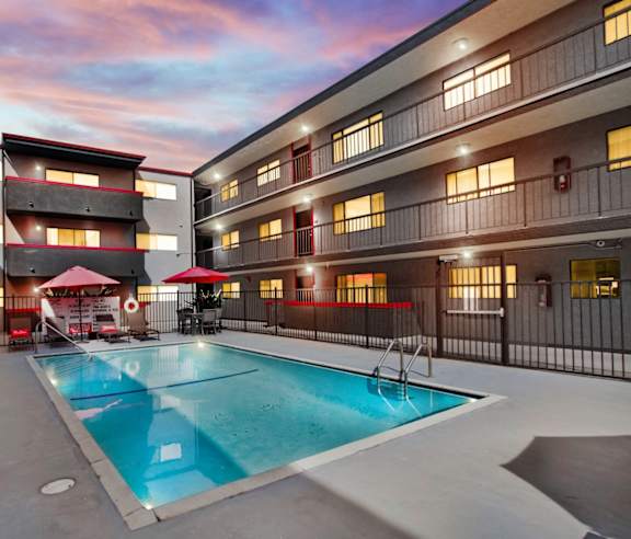 A swimming pool in a courtyard surrounded by buildings.