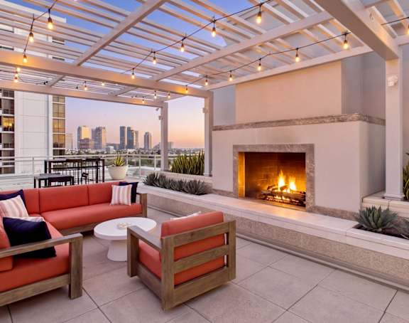 A patio with a fireplace and a view of the city.