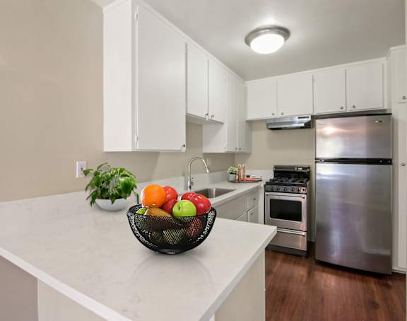 A kitchen with a bowl of fruit on the counter.