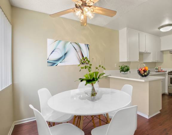 A dining room with a white table and chairs.