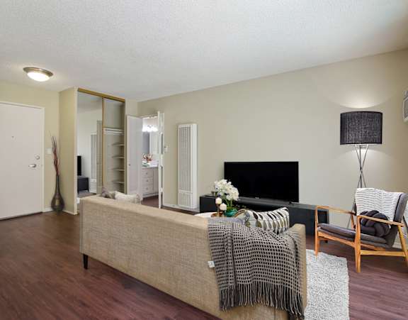 A living room with a couch, chair, and a mirrored-sliding closet