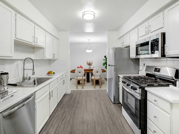 a kitchen with stainless steel appliances and white cabinets