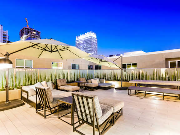 A rooftop patio with a table and chairs.