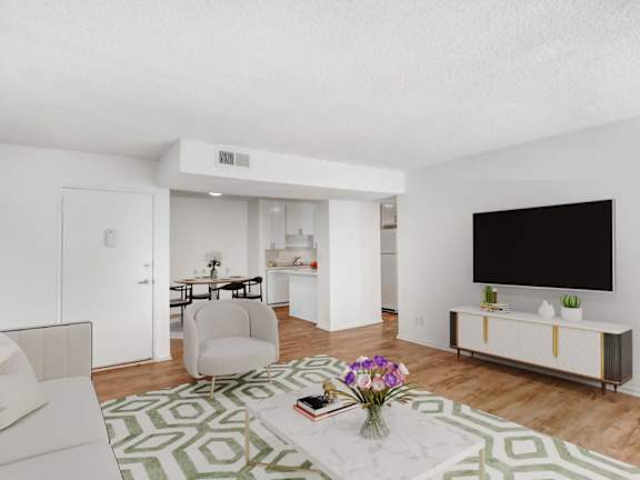 A living room with a white couch, a white chair, a white coffee table, a white cabinet, a white TV, a white rug, and a white wall.