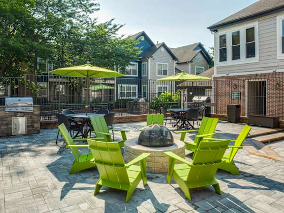 A patio with green chairs and umbrellas at Heritage at Waters Landing, Germantown, MD, 20874