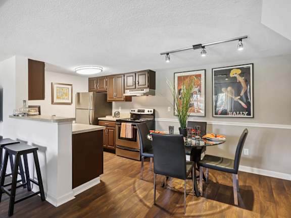 A kitchen with a bar area and a dining table with chairs at Whisper Lake Apartments, Winter Park, 32792