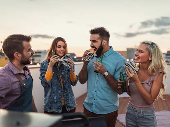 A group of people toasting with drinks at a bar.