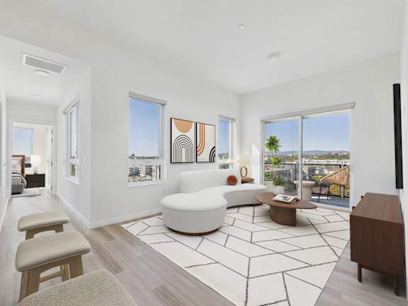 A living room with a white sofa and a large window.