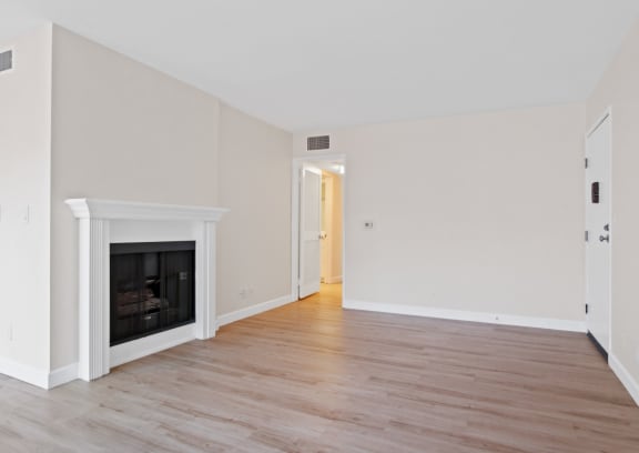 a bedroom with a fireplace and hardwood floors