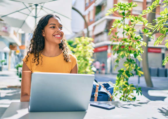 a woman sitting at a table with a laptop