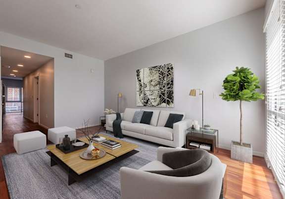 a living room with white couches and chairs and a wooden table