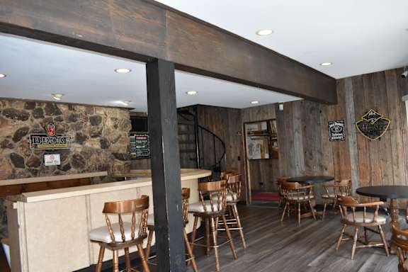 a bar with wooden chairs and a staircase
