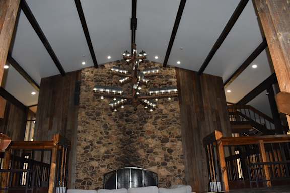 a living room with a stone wall and a chandelier