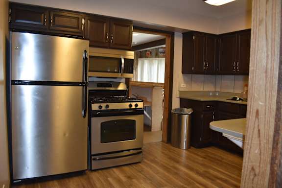 a kitchen with stainless steel appliances and a wooden floor