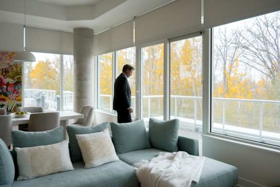 A living room with a green armchair and a white couch. at Petries Landing I Apartments , Ottawa