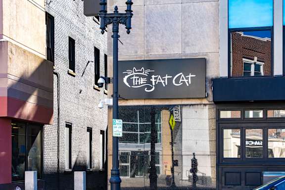 A street view of a building with a sign that reads "The Fat Cat".