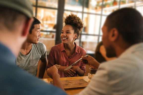 A group of people are sitting around a table, engaged in conversation.