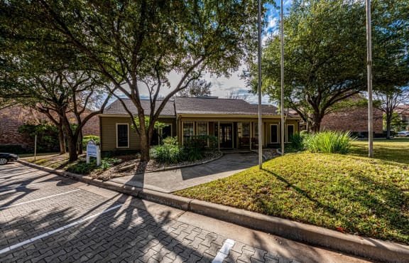 a house with a driveway and trees in front of it