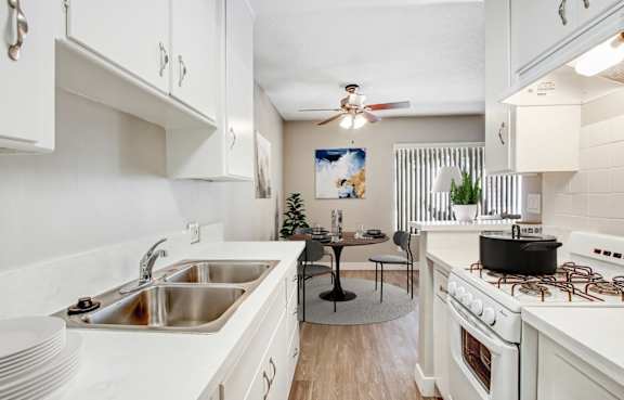 A kitchen with white cabinets and a black table.