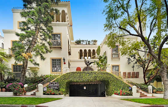 A large white house with a black gate in front.