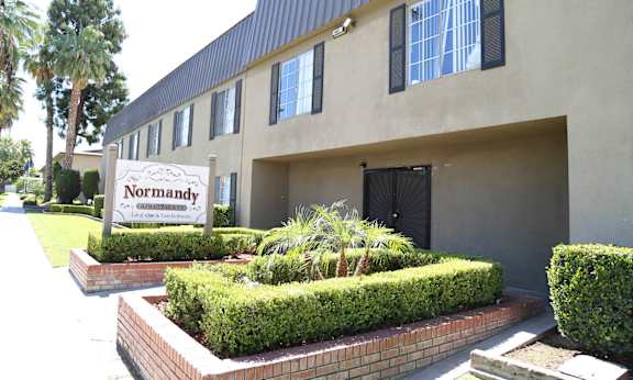 A building with a sign that says Normandy in front of it.