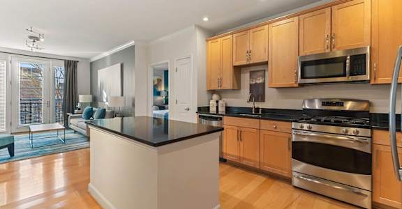 A kitchen with wooden cabinets and a black countertop.