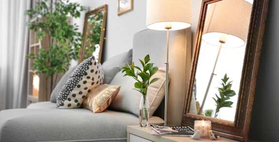 a small living room with a couch and a mirror