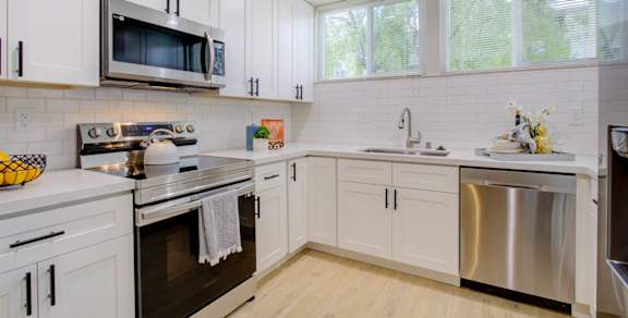 a kitchen with white cabinets and stainless steel appliances