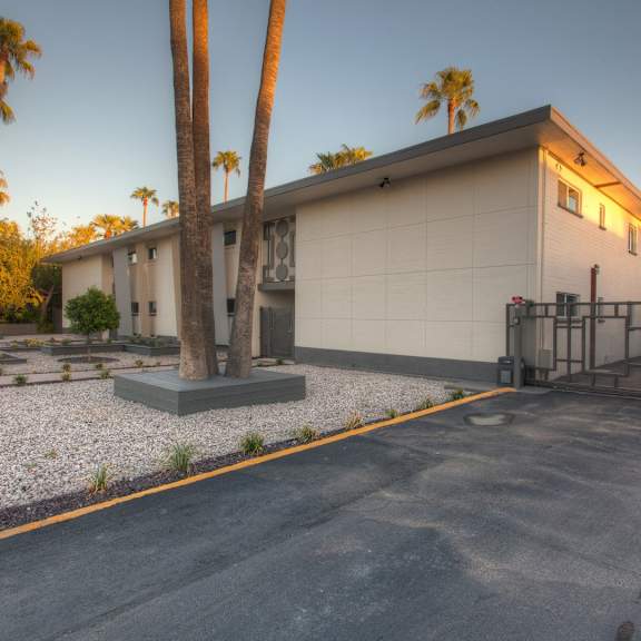 the exterior of a building with palm trees in front of it