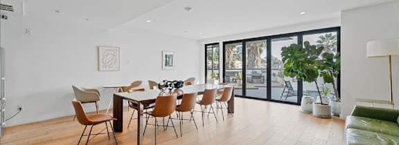 A modern dining room with a wooden table and chairs.