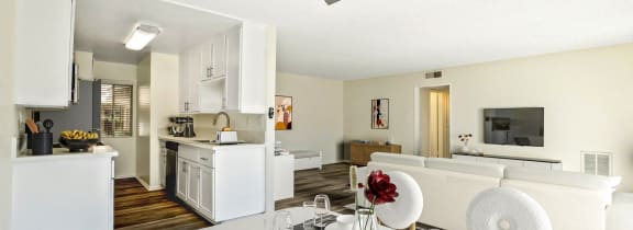 a living room and dining room with a table and a ceiling fan