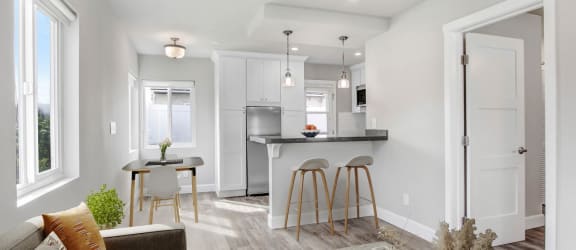 a living room with a kitchen with a bar and a couch