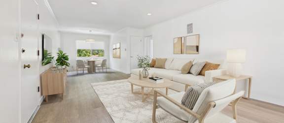 A living room with a white couch and a wooden floor.