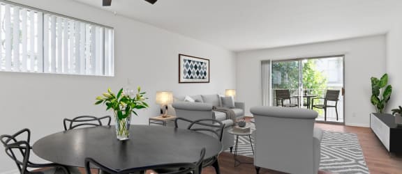 a living room with a dining room table and a ceiling fan