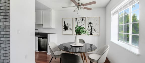 a dining room with a table and chairs and a ceiling fan