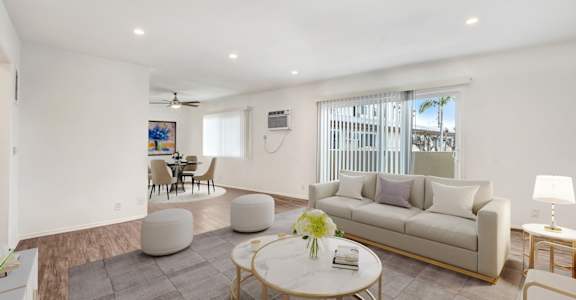 a living room with a white couch and a glass table