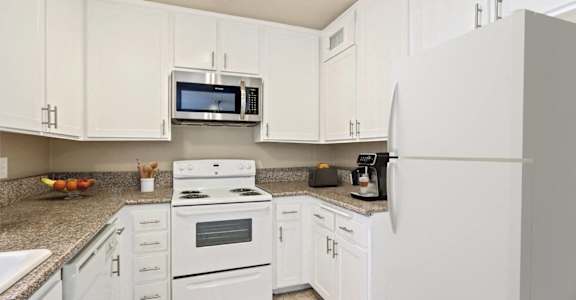 a kitchen with white appliances and white cabinets