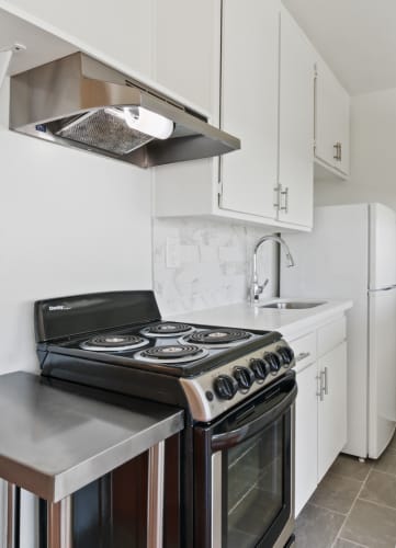a kitchen with white cabinetry and a black stove top oven