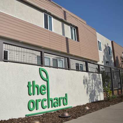 The Orchard building has a white sign with green lettering.