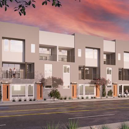 A modern apartment building with balconies and orange accents on the doors and windows.