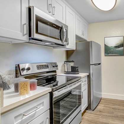 a kitchen with stainless steel appliances and white cabinets