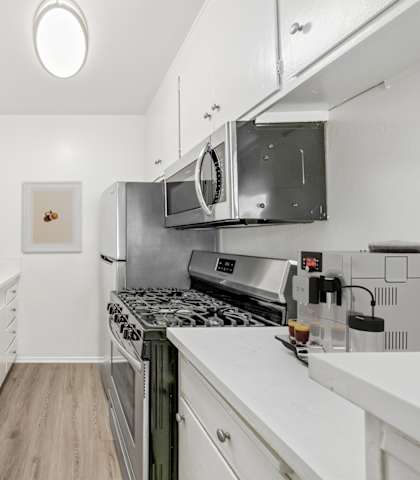 a modern kitchen with white cabinets and stainless steel appliances