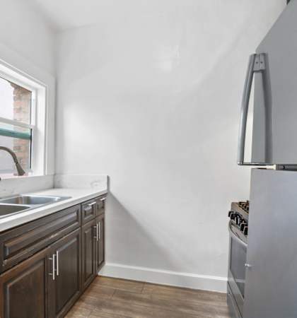 a kitchen with white walls and wooden cabinets