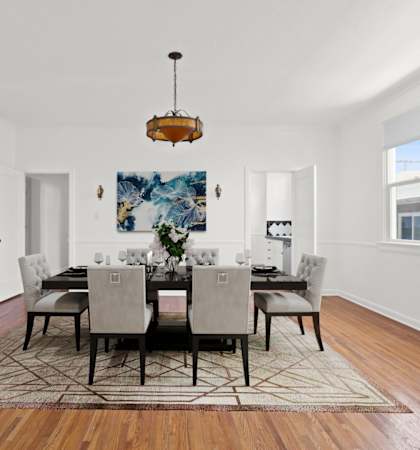 a dining room with a large table and chairs and a rug