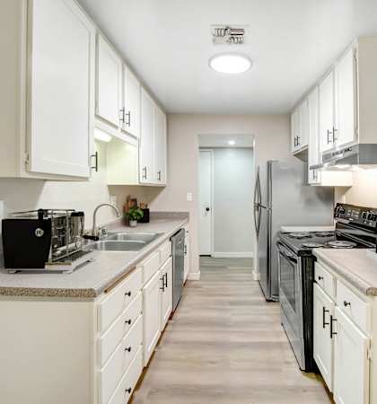 a large kitchen with white cabinets and stainless steel appliances