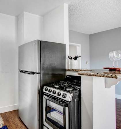 A kitchen with a black stove top oven and a white refrigerator.