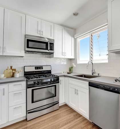 A kitchen with white cabinets and stainless steel appliances.