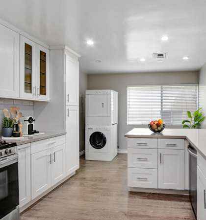 a kitchen with white cabinets and a white washer and dryer