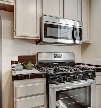 a kitchen with white cabinets and stainless steel appliances