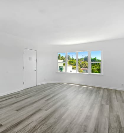an empty living room with white walls and a window